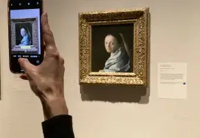 A museum-goer snapping a photo of Johannes Vermeer’s “Study of a Young Woman” (ca. 1665-67) at the Metropolitan Museum of Art in New York (photo by Hakim Bishara for Hyperallergic)