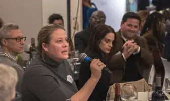 Seated woman speaks into microphone at event about democracy in Lexington, Kentucky